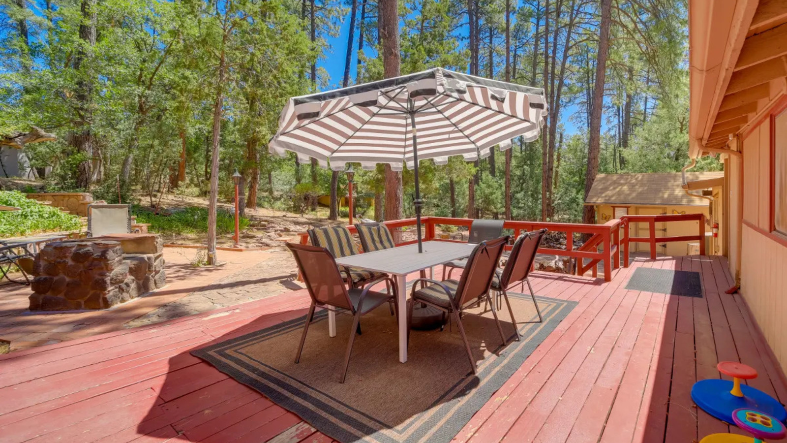 Covered deck with outdoor dining overlooking trees.