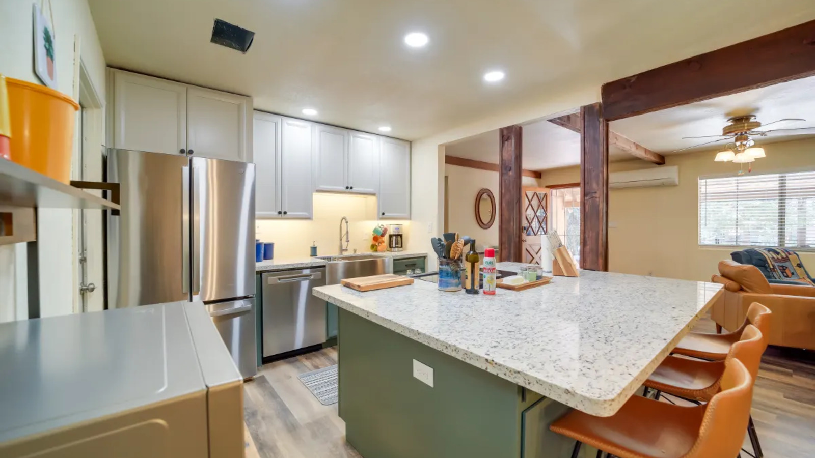 Bright kitchen with green island and bar seating.